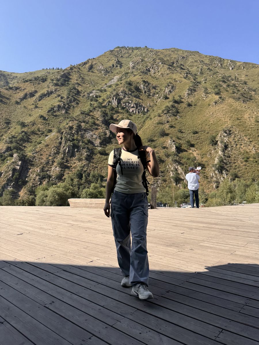 Dinara walking on a mountain path in the sunshine